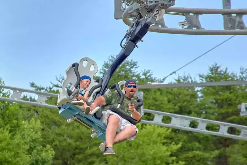 family riding the Ski Lift Shootout Coaster at Rowdy Bear