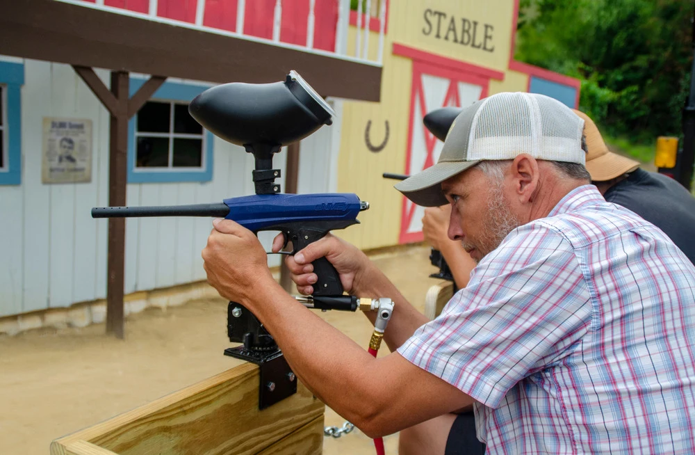 taking aim with blaster at Trigger Town Old West Paintball