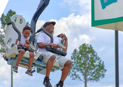 father and son riding laser gun coaster