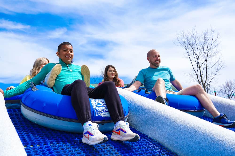 family riding down our outdoor tubing hill