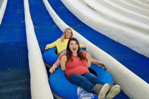 two girls on rowdy bear's smoky mountain snowpark tubing hill in pigeon forge