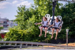 two girls holding lasers while riding the Ski Lift Shootout Coaster