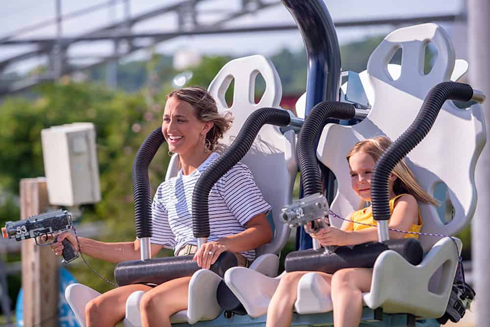 mother and daughter riding the Ski Lift Shootout Coaster at rowdy bear's smoky mountain snowpark