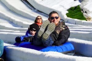father and son riding down a snow tubing hill in pigeon forge
